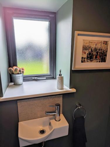 a bathroom with a sink and a window at The Cob House. in Ifton Heath