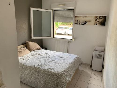 une petite chambre avec un lit et une fenêtre dans l'établissement Super appartement arboré avec barbecue et parking, à Valence