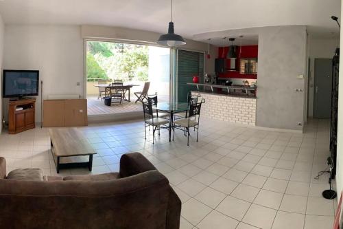 un salon et une cuisine avec un canapé et une table dans l'établissement Super appartement arboré avec barbecue et parking, à Valence