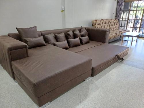 a brown couch sitting in a living room at Paradise Found 4BR Villa,Fits 22 PAX, 6-Min to Lee Garden in Hat Yai
