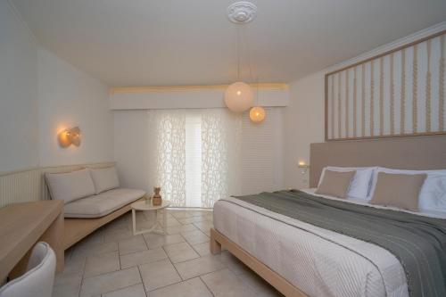 una camera da letto con un letto grande e un divano di Arkadia Hotel a Kypseli