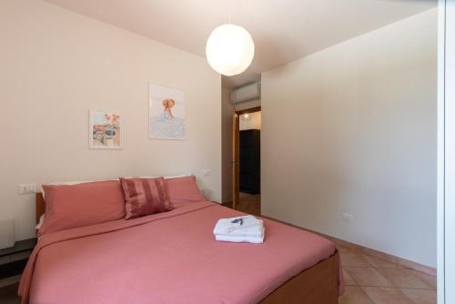 a bedroom with a bed with a pink blanket at L'Antica Colombaia Appartamenti in Ostra