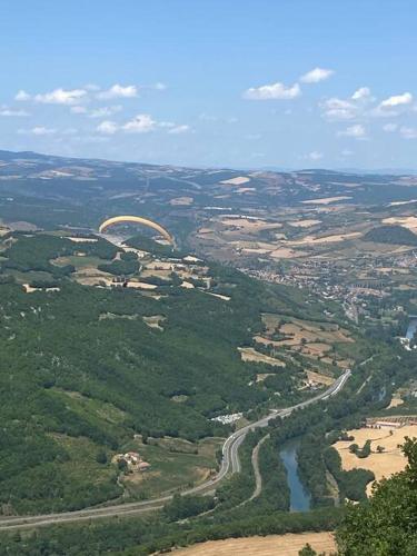 an aerial view of a city with a river and a bridge at La maison d autrefois in Aguessac