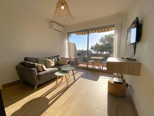 un salon avec un canapé et une table dans l'établissement Appartement vue mer, au calme, proche de toutes commodités, à Fréjus