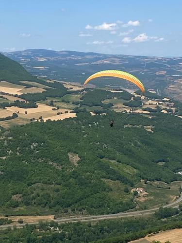 a paraglider flying in the air over a field at La maison d autrefois in Aguessac