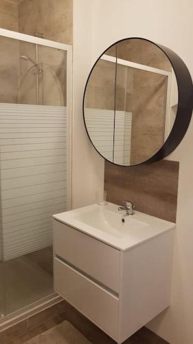 une salle de bain avec un lavabo blanc et un miroir dans l'établissement Studio en plein centre Valence, à Valence