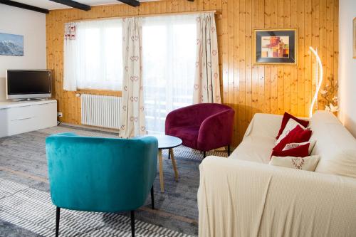 a living room with a couch and chairs and a tv at Ski in Ski out Family accommodation Chesa Katja Lenzerheide in Valbella