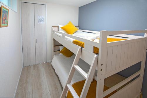 two bunk beds in a small room with a ladder at 西九条【新築一軒家】駅近・アクセス良好＊OSAKA＊NAMBAエリア＊NewOpen!! FreeWifi in Osaka