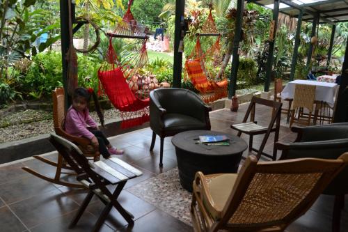 a little girl sitting in a chair in a restaurant at Posada Las Bromelias in Silvania