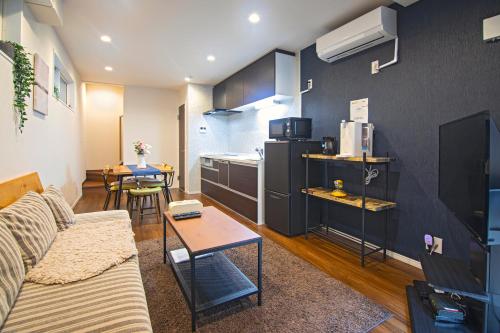 a living room with a couch and a kitchen at 西九条【新築一軒家】駅近・アクセス良好＊OSAKA＊NAMBAエリア＊NewOpen!! FreeWifi in Osaka