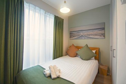 a small bedroom with a bed and a window at 西九条【新築一軒家】駅近・アクセス良好＊OSAKA＊NAMBAエリア＊NewOpen!! FreeWifi in Osaka