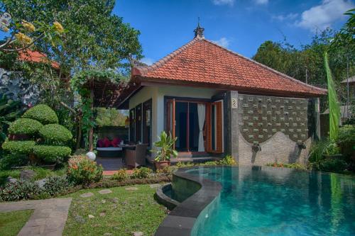 a house with a swimming pool in front of it at Baruna Sari Villa in Ubud