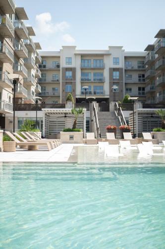 a swimming pool with chairs and buildings in the background at 5 Min from everything! Pool, Gym, Balcony in Houston