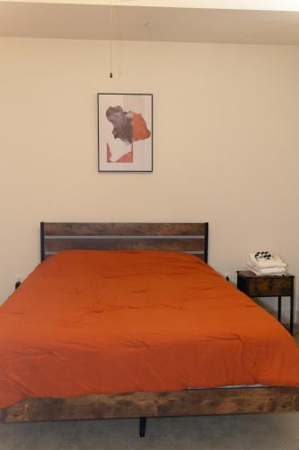 a bedroom with a bed with an orange blanket at 5 Min from everything! Pool, Gym, Balcony in Houston