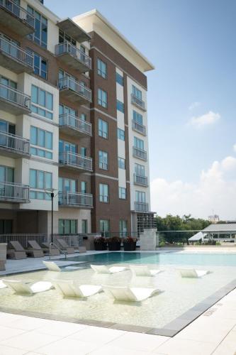 a building with a swimming pool in front of a building at 5 Min from everything! Pool, Gym, Balcony in Houston