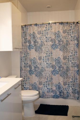 a bathroom with a toilet and a shower curtain at 5 Min from everything! Pool, Gym, Balcony in Houston