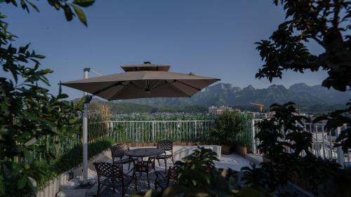 a patio with a table and chairs and an umbrella at Patio Spring Holiday Inn -- Free round trip pick-up service --Panoramic view of Tianmen Mount in Zhangjiajie