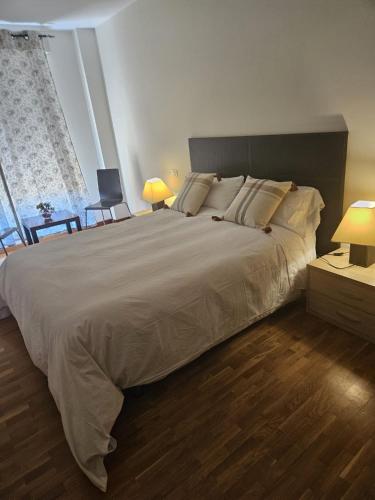 una camera da letto con un letto grande e una grande finestra di Apartamento en Lardero 4 Pax, parking incluido a Lardero