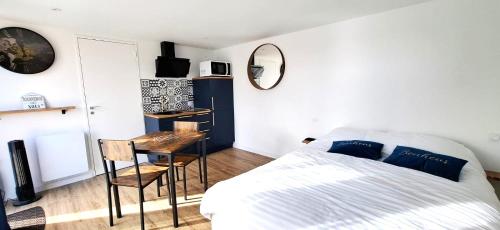 une chambre avec un lit, un bureau et un miroir dans l'établissement Location Finistère Jaccuzi privé, à Plougourvest
