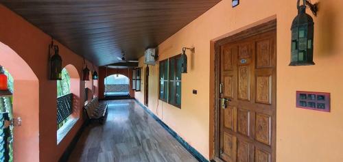 an empty hallway of a building with a wooden door at Chira Meadows Ecoresort, Dapoli in Dapoli