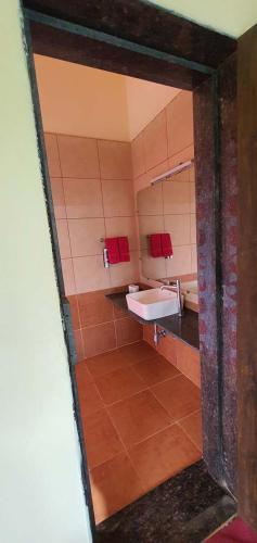 a bathroom with a sink and a mirror at Chira Meadows Ecoresort, Dapoli in Dapoli