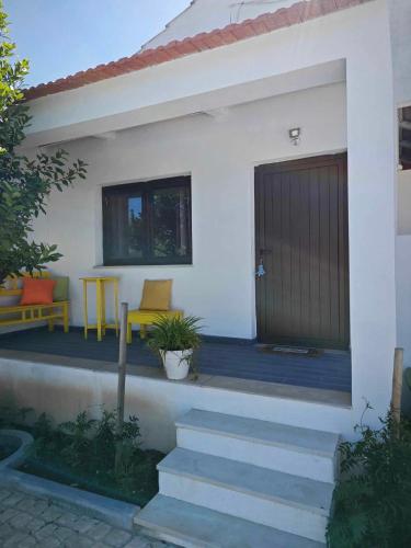a house with a porch with two chairs and a door at Herdade di Luce in Daporta