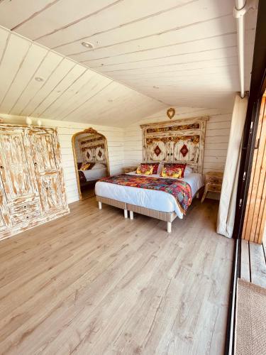 une chambre avec deux lits et un parquet dans l'établissement MAS DES PAZ, à Aigues-Mortes