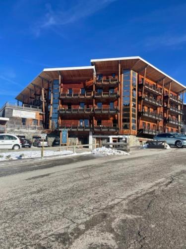 a large apartment building in front of a parking lot at Les Edelweiss " les Balcons de Recoin" in Chamrousse