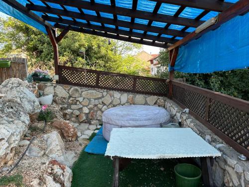 a patio with a table and a stone wall at Panorama Kinneret נוף כנרת, צפת in Safed
