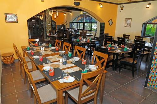 a dining room with wooden tables and chairs at Chira Meadows Ecoresort, Dapoli in Dapoli