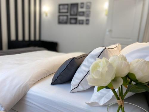 a bed with pillows and a vase with white flowers at Studio Luxury Black & White in Alba Iulia