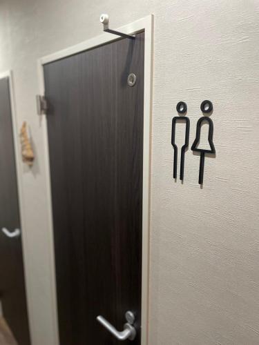 a bathroom door with a toilet sign on a wall at fleuve tenmonkan in Yamashitachō