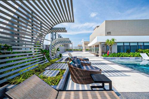 a resort with a pool and chairs and a building at The Sóng Vũng Tàu - Mochi House in Vung Tau