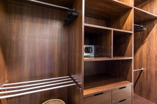 a closet with wood paneling and a microwave at Phuket Pool Residence - Adults only in Rawai Beach
