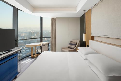 a hotel room with a bed and a television at Sheraton Zibo Hotel in Zibo