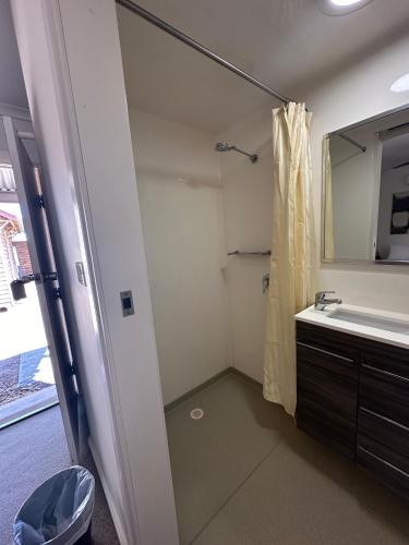 bagno con doccia, lavandino e specchio di Parachilna Overflow Accommodation a Flinders Ranges
