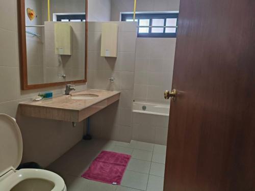 Un baño con lavabo, inodoro y espejo. en Tanwa Suite - MRT Ratchadapisek, en Bangkok