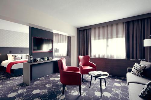 a hotel room with a bed and a red chair at Mercure Orange Centre A7/A9 in Orange