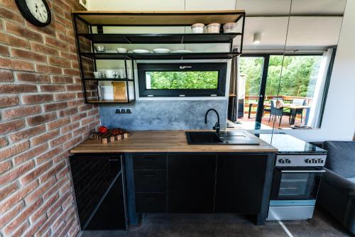 a kitchen with a sink and a brick wall at WUDINO - Ubytování v přírodě, se zvířaty v industriálním duchu, in Ostrov u Macochy