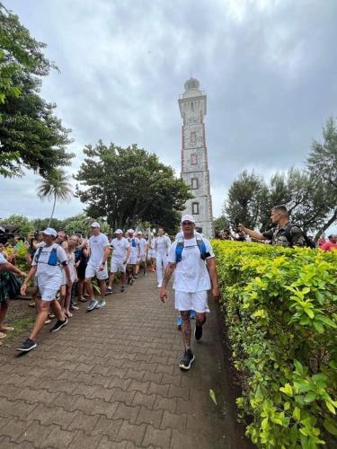 a group of people walking in front of a clock tower at La maison près du Phare in Mahina