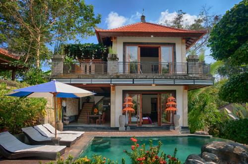 a villa with a swimming pool in front of a house at Baruna Sari Villa in Ubud