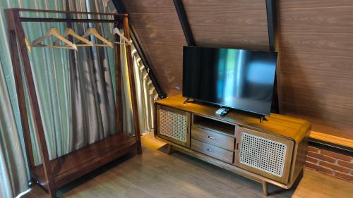 a television sitting on top of a wooden cabinet at Harmony Magelang Syariah in Bendo