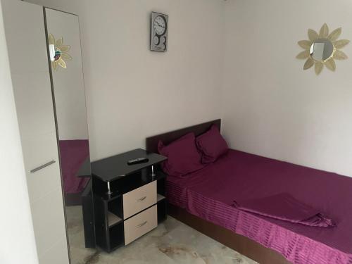 a small bedroom with a purple bed and a mirror at Beta Residence Saturn in Mangalia