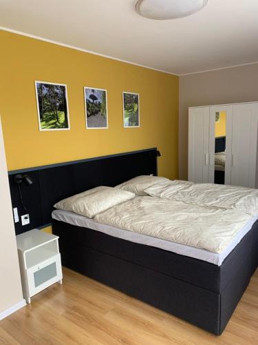 a bedroom with a large bed with yellow walls at Garden Apartments in Kráľovský Chlmec