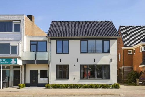 a white house with black windows on a street at Studio 44 in Waalre