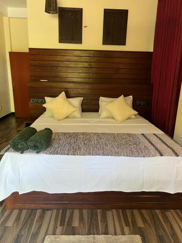 a bedroom with a large bed with a wooden headboard at Green turtle in Tangalle