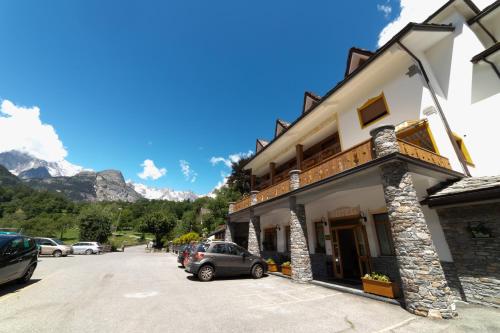 a building with a car parked in a parking lot at Hotel Beau Sejour Pré-Saint-Didier in Pré-Saint-Didier