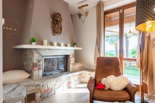 a living room with a fireplace and a chair at Home Sweet Home Garden & Lake View - Happy Rentals in Besozzo