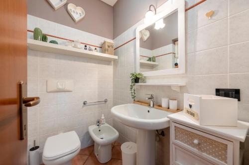 a white bathroom with a sink and a toilet at Home Sweet Home Garden & Lake View - Happy Rentals in Besozzo