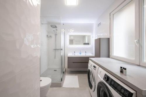 La salle de bains blanche est pourvue de toilettes et d'un lave-linge. dans l'établissement Magnifique appartement au cœur du 5ème arrondissement de Paris, à Paris